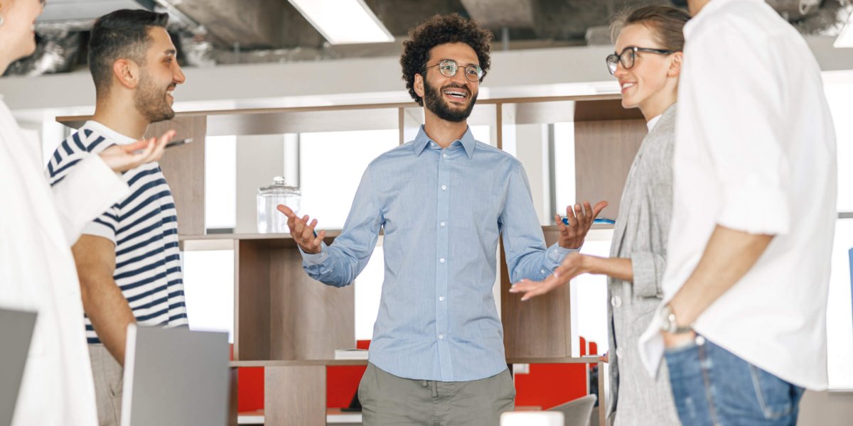 Happy group of businesspeople laughing cheerfully in a modern workplace. Blurred background