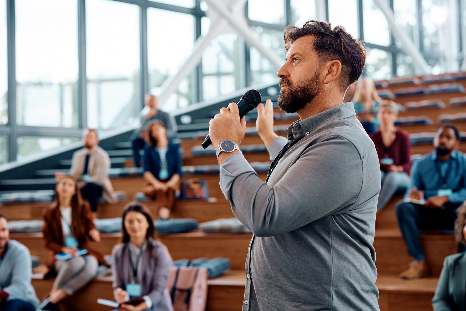 male instructor standing and speaking to large group workshop for active shooter training for employees