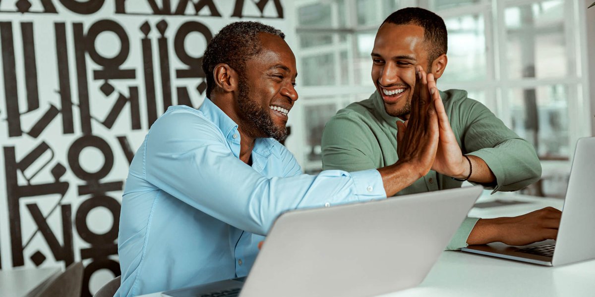 two business people at laptops completing their ethics training in the workplace