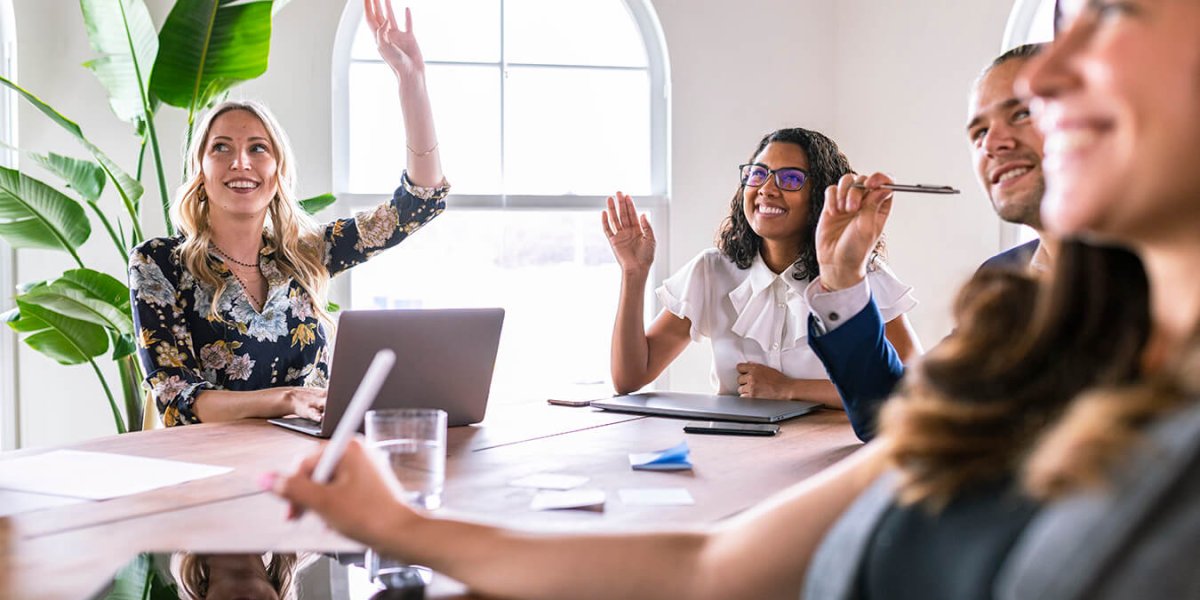 employee raising hand in conflict management training course discussing conflict resolution skills