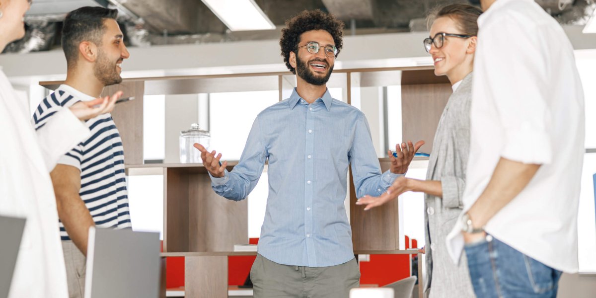 Happy group of businesspeople laughing cheerfully in a modern workplace. Blurred background