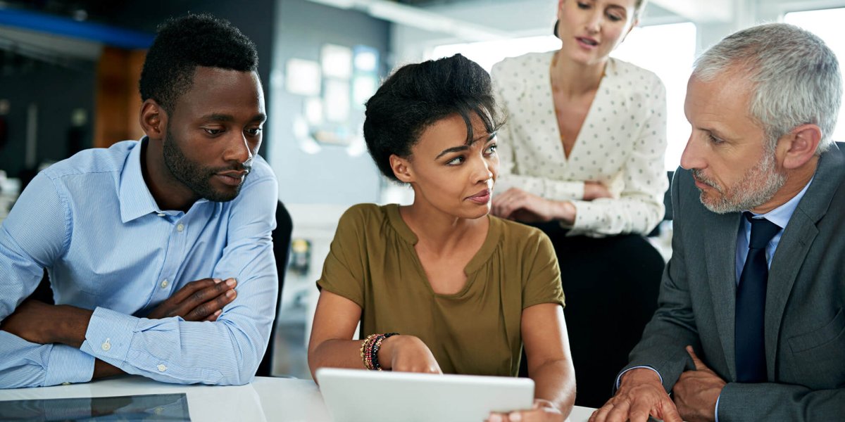 Female manager sitting and reviewing work policy on how to comply California SB 553 violence prevention with group of employees