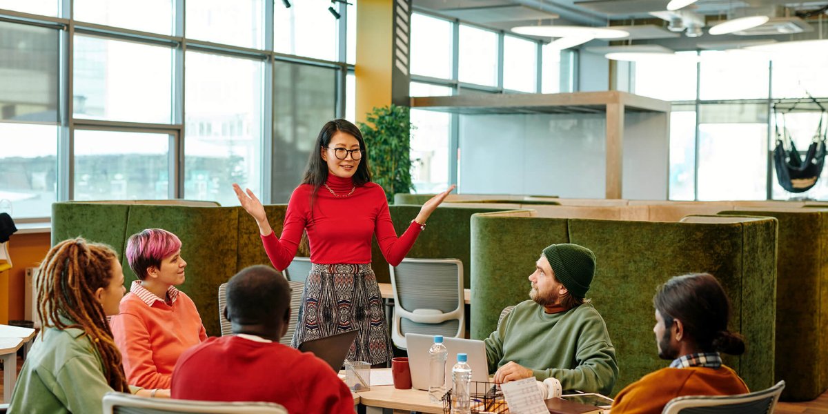 Female trainer reviewing the California Sexual Harassment Update for 2026 to young diverse group of employees at table in office