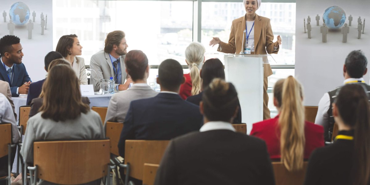 Female DEI presenter training a group of corporate employees